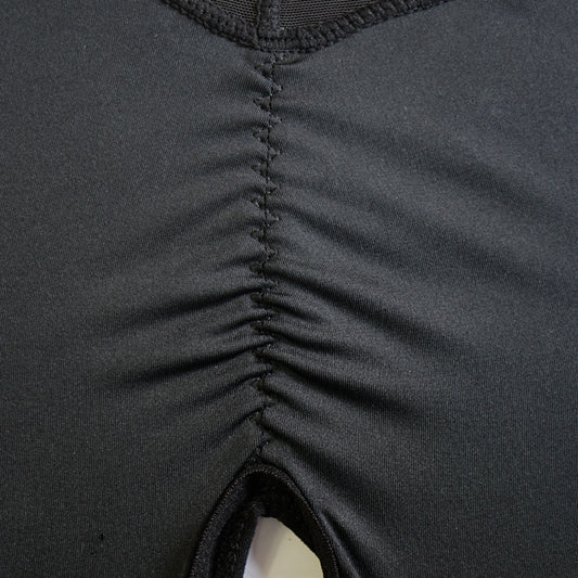 Full-body women’s shapewear bodysuit with front zipper closure, deep V-neckline, and mid-thigh smoothing coverage