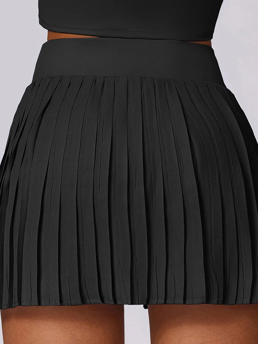 A sporty classic with a fresh street-style edge- High-Waisted Asymmetric Pleated Skort — Black/Pockets